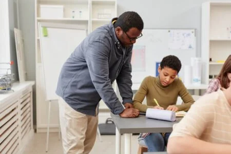 Gauteng Province Launches Teacher Development System black teacher helping girl in class